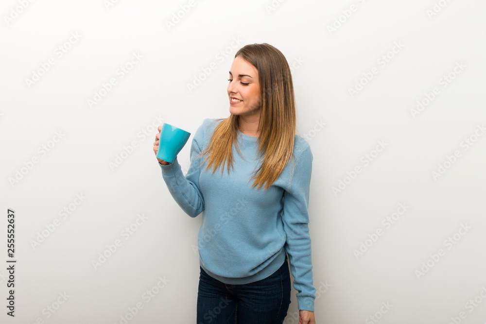 Blonde woman on isolated white background holding a hot cup of coffee Blonde woman on isolated white background holding a hot cup of coffee