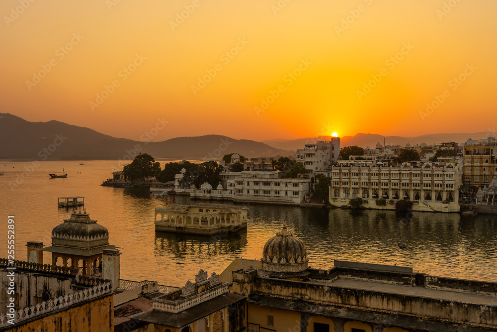 Colorful sunset above architecture and lake water in Udaipur, Rajasthan, India