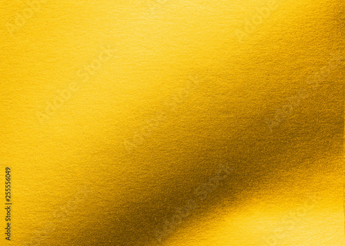 Gold paper texture background metallic golden foil or shiny wrapping bright yellow wallpaper sheet for design decoration element