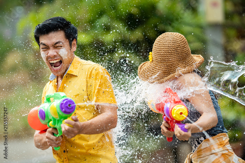 Asian people are using water guns play in the Songkran festival photo