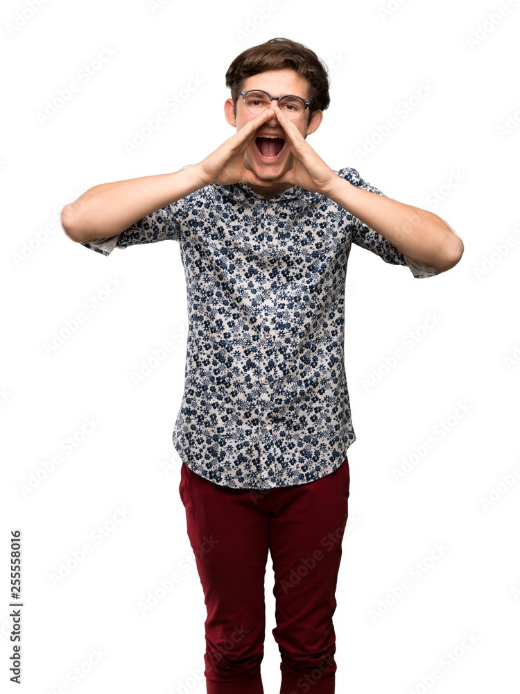 Teenager man with flower shirt and glasses shouting and announcing something over isolated white background Teenager man with flower shirt and glasses shouting and announcing something over isolated white background
