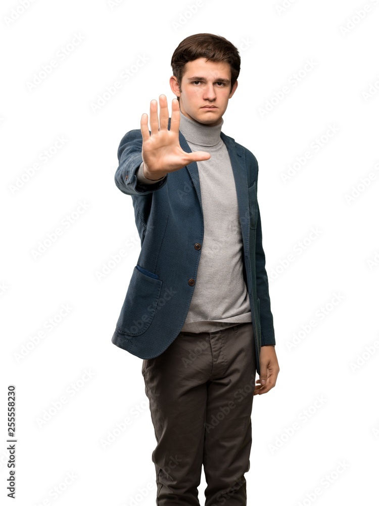 Teenager man with turtleneck making stop gesture denying a situation that thinks wrong over isolated white background Teenager man with turtleneck making stop gesture denying a situation that thinks wrong over isolated white background