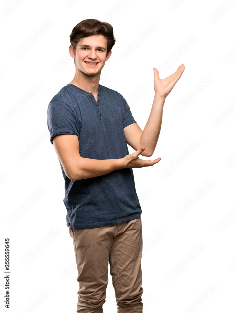 Teenager man extending hands to the side for inviting to come over isolated white background Teenager man extending hands to the side for inviting to come over isolated white background