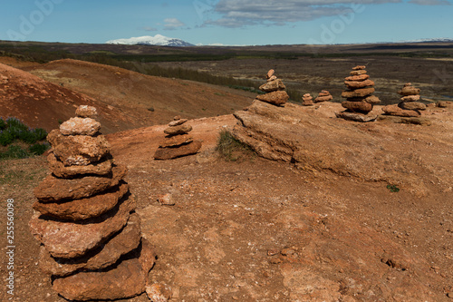 Fotografie, Tablou Series of red rock cairns near the Geysir Hot Springs in the Golden Circle area