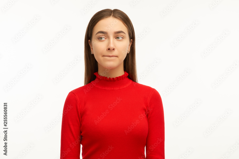 Puzzled woman keeps lips pressed, has frustrated facial expression, frowns face in displeasure, being deep in thoughts. Female dressed in casual outfit, models over white wall with copy space Puzzled woman keeps lips pressed, has frustrated facial expression, frowns face in displeasure, being deep in thoughts. Female dressed in casual outfit, models over white wall with copy space
