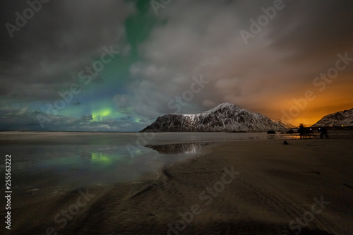 Photographers with tripods during aurora borealis hunting at Skagsanden beach. Lofoten Islands, Norway, Scandinavia