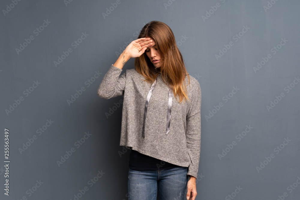 Blonde woman over grey background with tired and sick expression Blonde woman over grey background with tired and sick expression