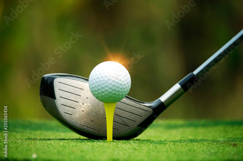 Golf ball and golf club in beautiful golf course with sunset background.