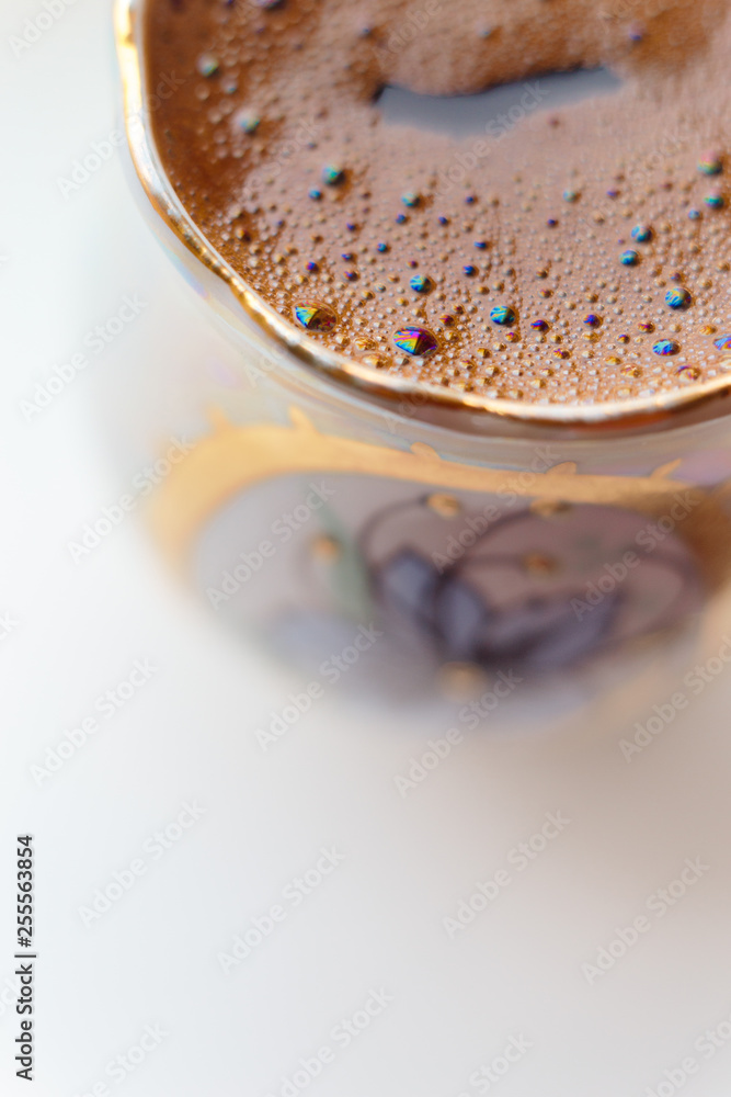 ISOLATED: Macro shot of brewed coffee in a round cup - Rainbow sparkles with bubbles ISOLATED: Macro shot of brewed coffee in a round cup - Rainbow sparkles with bubbles