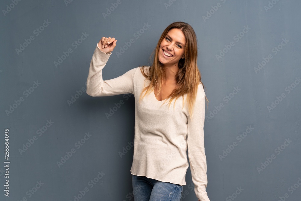 Blonde woman over grey background smiling Blonde woman over grey background smiling