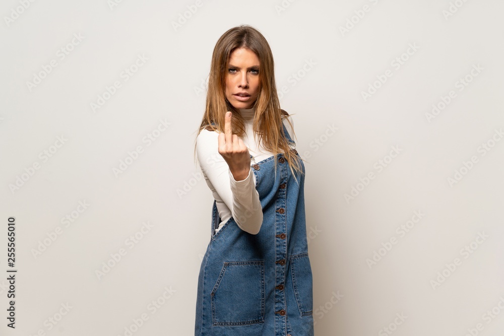 Beautiful woman over isolated white wall making horn gesture Beautiful woman over isolated white wall making horn gesture