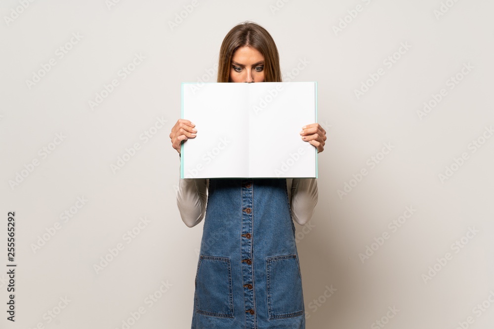 Beautiful woman over isolated white wall holding a placard for insert a concept Beautiful woman over isolated white wall holding a placard for insert a concept