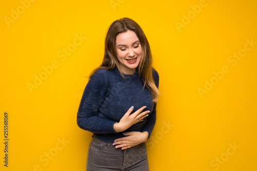 Teenager girl over yellow wall smiling a lot © luismolinero