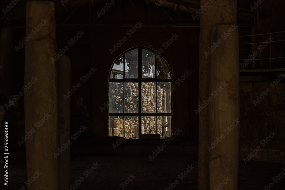ruined abandoned stone house building inside with symmetry columns and arch window frame in twilight darkness 