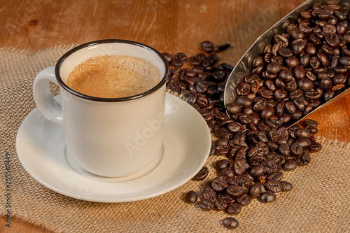 taza de café con granos esparcidos sobre madera