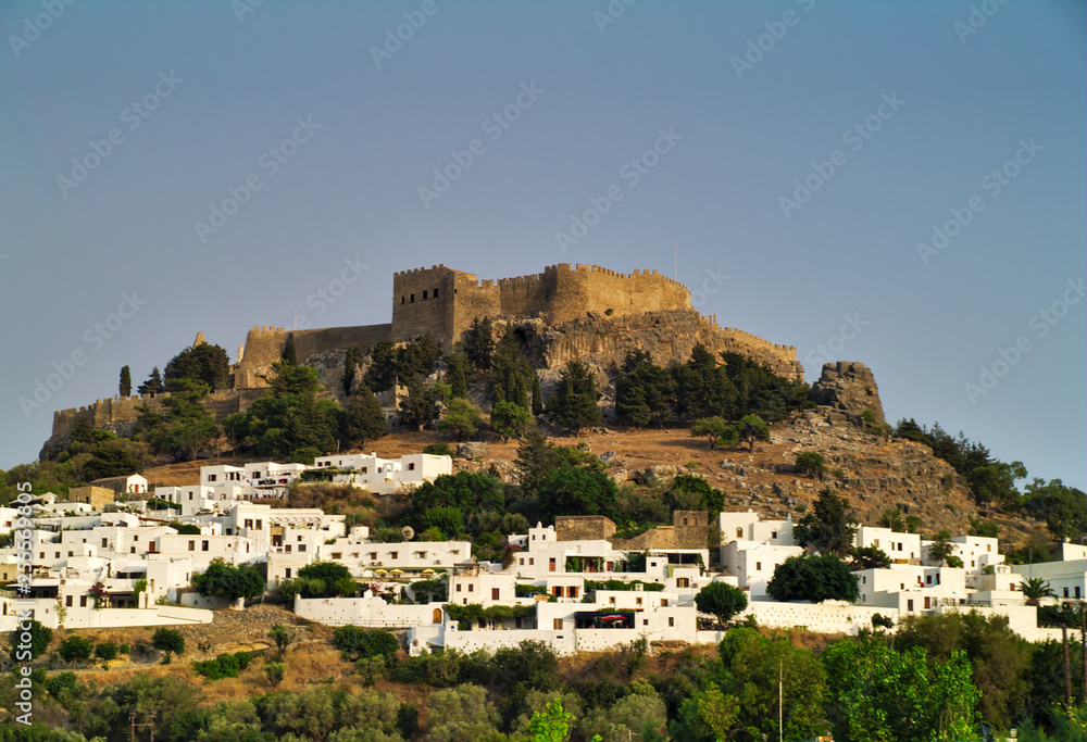 Acropolis of Lindos and city with white houses. Rhodes island, Greece. Clear summer day.
