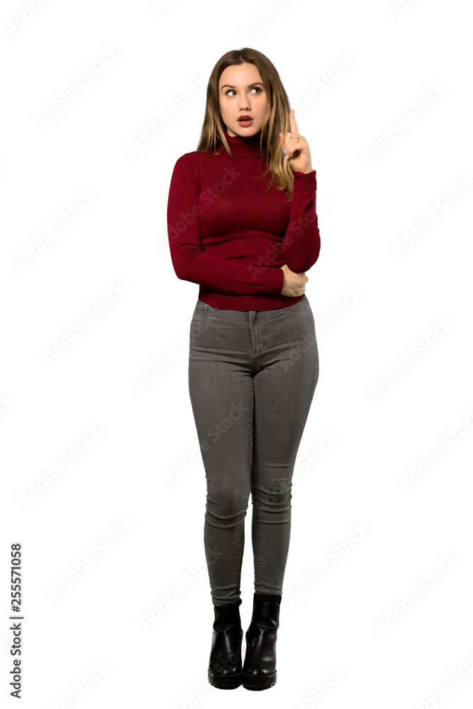 A full-length shot of a Teenager girl with turtleneck thinking an idea pointing the finger up over isolated white background A full-length shot of a Teenager girl with turtleneck thinking an idea pointing the finger up over isolated white background