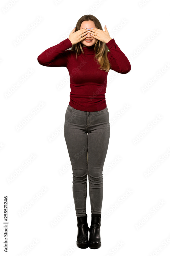Fototapeta premium A full-length shot of a Teenager girl with turtleneck covering eyes by hands. Surprised to see what is ahead over isolated white background