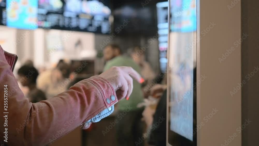 Woman Choosing Food Via Self-Service Machine at Fast Food Restaurant . People Using Self-Service Touch Terminal Makes a Purchase of Food Woman Choosing Food Via Self-Service Machine at Fast Food Restaurant . People Using Self-Service Touch Terminal Makes a Purchase of Food