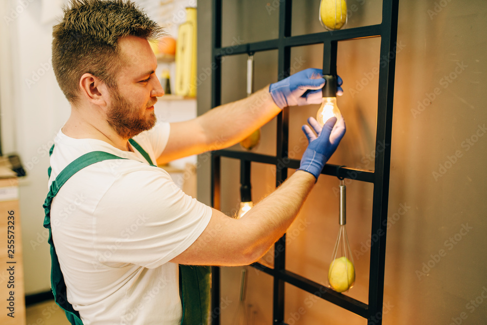 Electrician changes the light bulb, handyman Electrician changes the light bulb, handyman