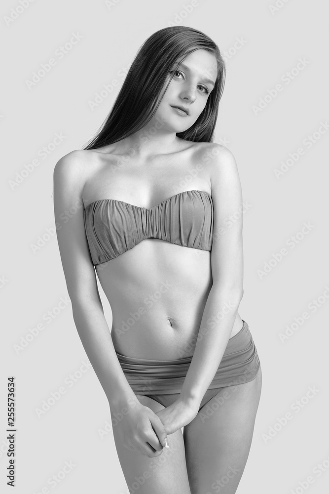 Naklejka premium Slim body of young woman in bikini on white . Girl with healthy sporty figure