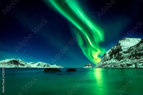 Beautiful green Northern Lights at Haukland Beach on the Lofoten Islands in Norway photo