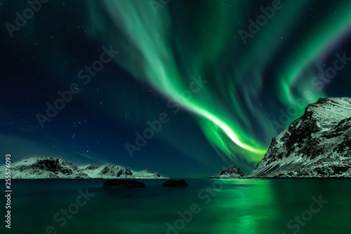 Beautiful green Northern Lights at Haukland Beach on the Lofoten Islands in Norway © Nils