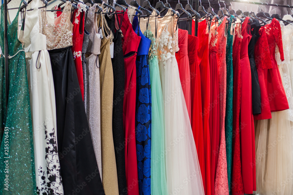 Beautiful elegant evening dresses on hangers in the showroom.