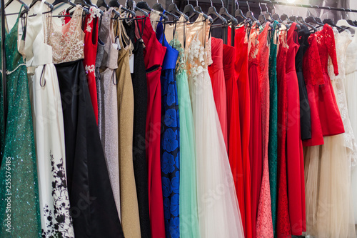 Beautiful elegant evening dresses on hangers in the showroom.