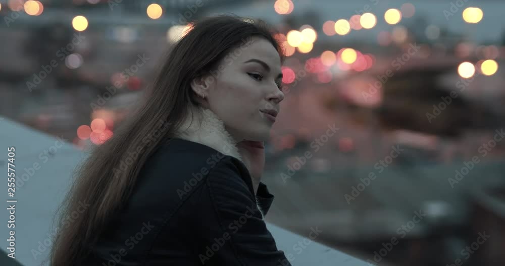 Young woman relaxing and looks forward to evening city scape Young woman relaxing and looks forward to evening city scape