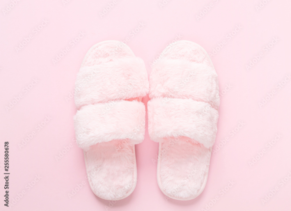 Composition of faux fur slippers on a light pink background. Morning concept. Flat Lay. Top View