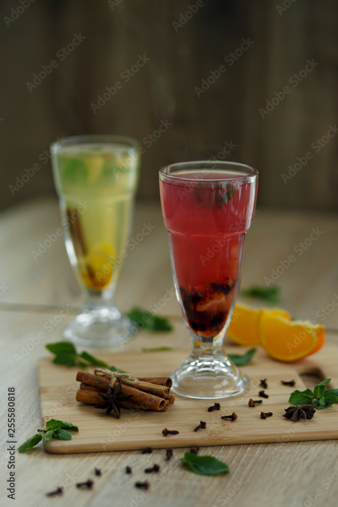two glasses with colored hot drinks from which steam comes. winter hot seasonal drinks two glasses with colored hot drinks from which steam comes. winter hot seasonal drinks