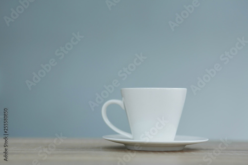Splash in white cup of coffee on wooden table