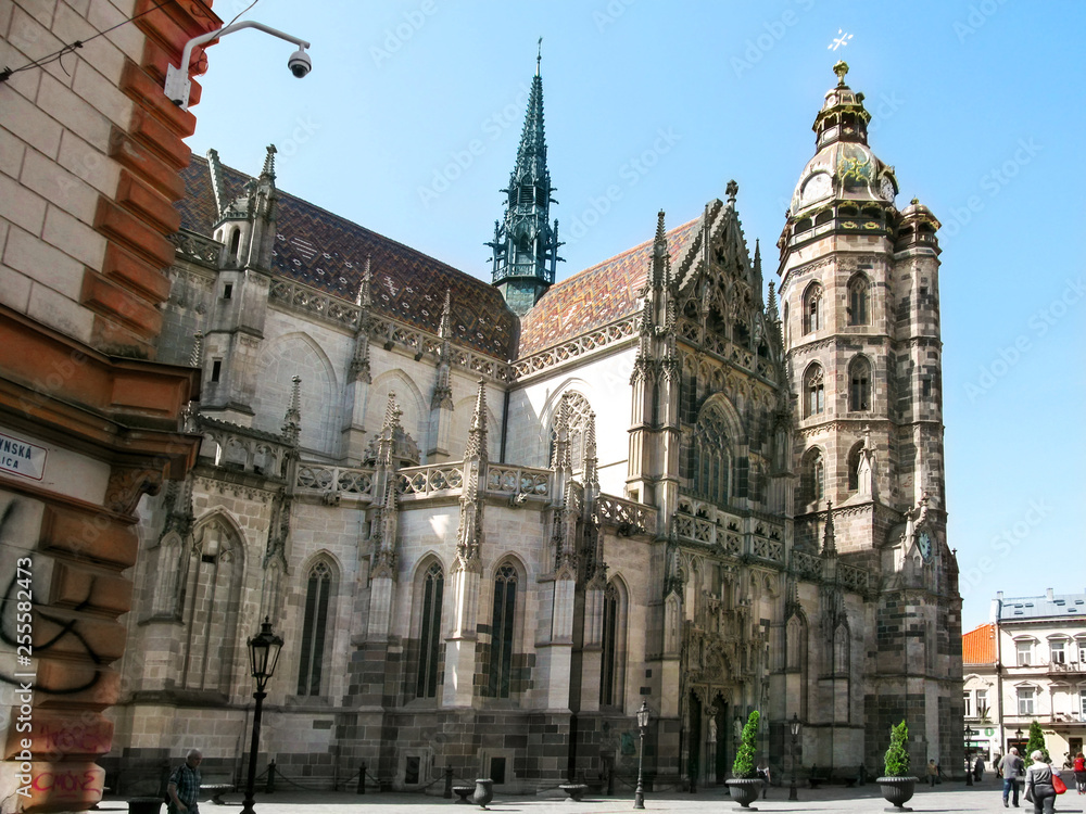 Kosice, Slovakia - May 2, 2018: Beautiful Gothic Cathedral of St. Elizabeth in Kosice. Ancient stone temple with a brown roof, a clock tower and stucco on the walls on a sunny spring-summer day