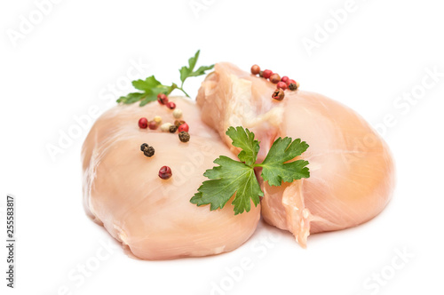 Raw chicken fillet with parsley and spices on white.