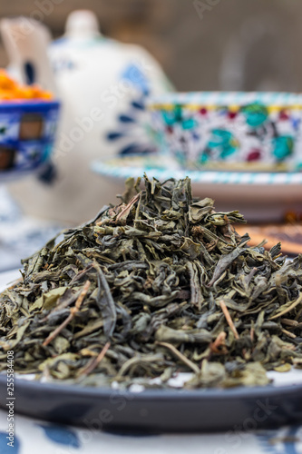Whole leaf green tea. Dried leafs of natural organic tea on dish.