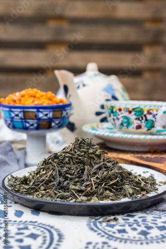 Whole leaf green tea. Dried leafs of natural organic tea on dish.