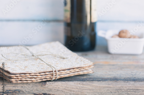 Pack of matzah or matza and red kosher wine on a vintage wood background. Jewish Passover holiday composition