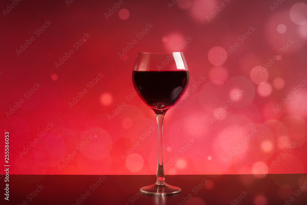 glass of wine on red background with bokeh glass of wine on red background with bokeh