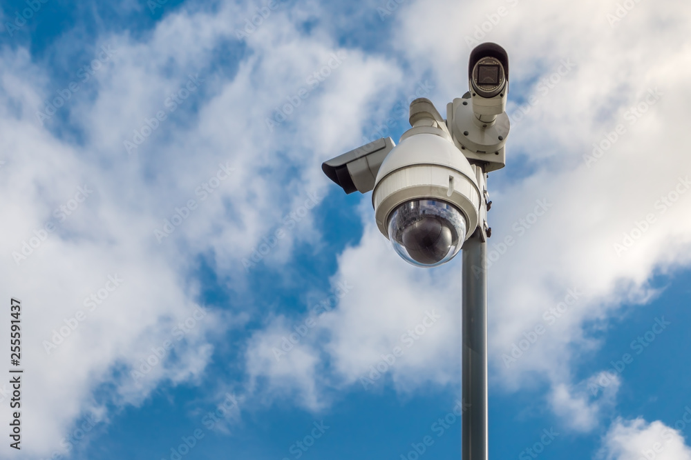 CCTV security cameras on pole on blue sky with white clouds background CCTV security cameras on pole on blue sky with white clouds background