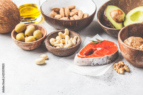 Healthy fat food background. Fish  nuts  oil  olives  avocado on white background.