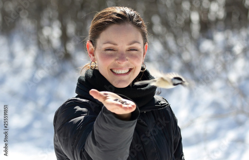 woman and little flying bird in nature during winter