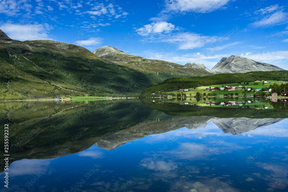 Idyllic landscape of Eidsvatnet lake near Geirangerfjord with mountains and villages reflected in the water, Sunnmore, More og Romsdal, Norway