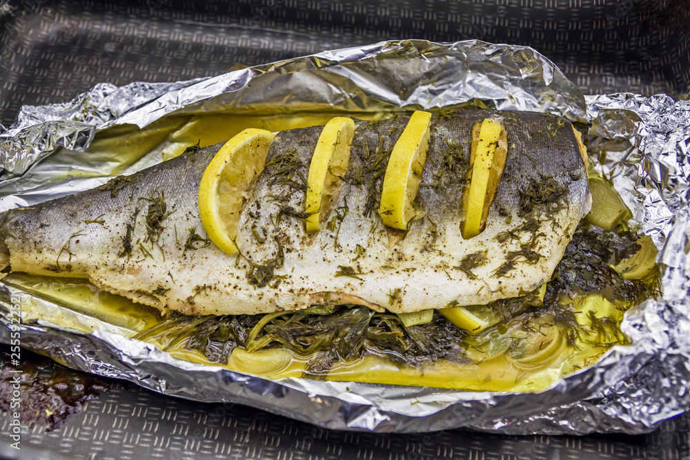 Sea fish baked in foil with spices and lemon