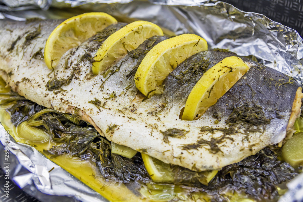 Sea fish baked in foil with spices and lemon