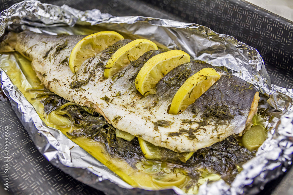 Sea fish baked in foil with spices and lemon