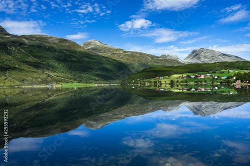 Idyllic landscape of Eidsvatnet lake near Geirangerfjord with mountains and villages reflected in the water, Sunnmore, More og Romsdal, Norway