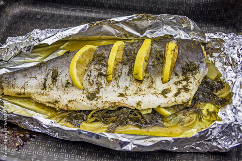 Obraz na płótnie Sea fish baked in foil with spices and lemon w salonie