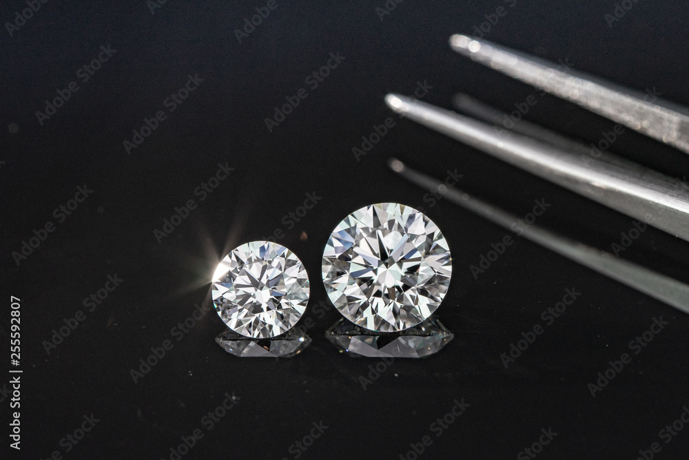 Compared 1.00 and 2.50 carat size diamonds on black background Compared 1.00 and 2.50 carat size diamonds on black background