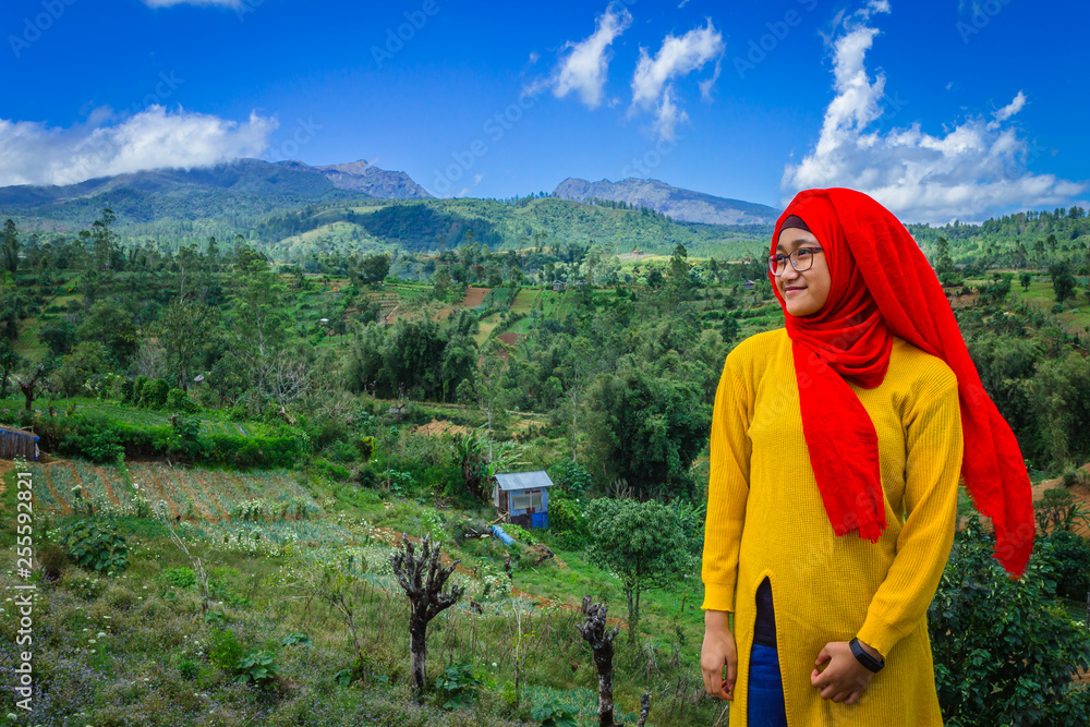 Naklejka premium A Muslim teen enjoying the view of beautiful landscape in Indonesia